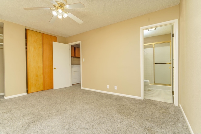 unfurnished bedroom with carpet flooring, connected bathroom, a textured ceiling, washer / dryer, and baseboards