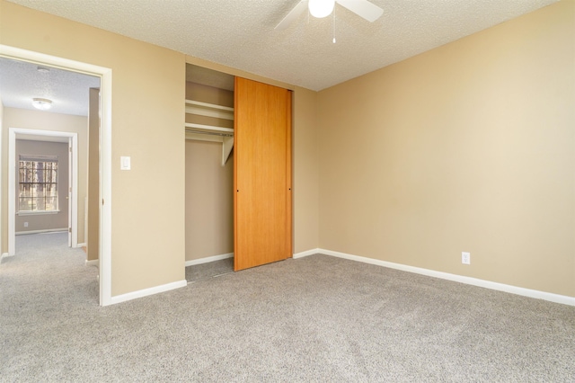 unfurnished bedroom with carpet, a textured ceiling, baseboards, and a closet