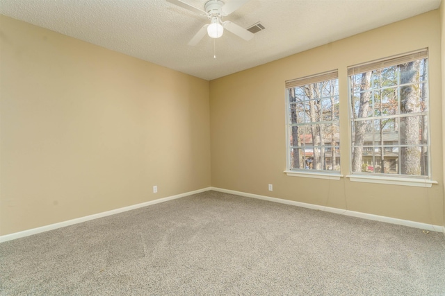 unfurnished room featuring a textured ceiling, ceiling fan, carpet flooring, visible vents, and baseboards