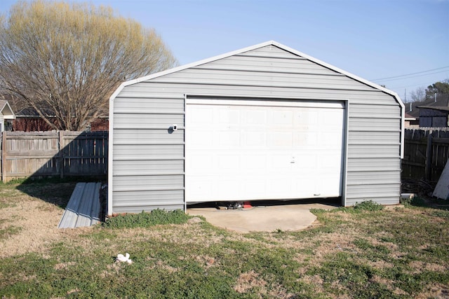 detached garage featuring fence