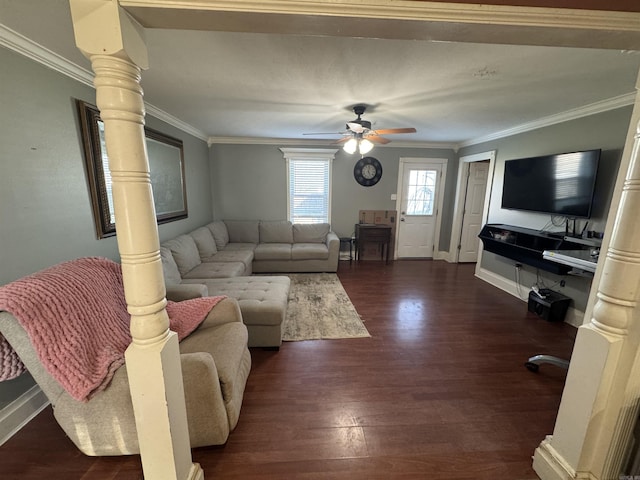 living room featuring decorative columns, baseboards, a ceiling fan, dark wood-type flooring, and crown molding