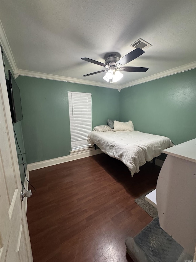 bedroom featuring a textured ceiling, wood finished floors, visible vents, and crown molding