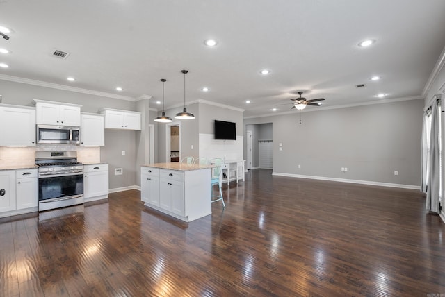 kitchen featuring a kitchen breakfast bar, open floor plan, appliances with stainless steel finishes, backsplash, and dark wood-style floors