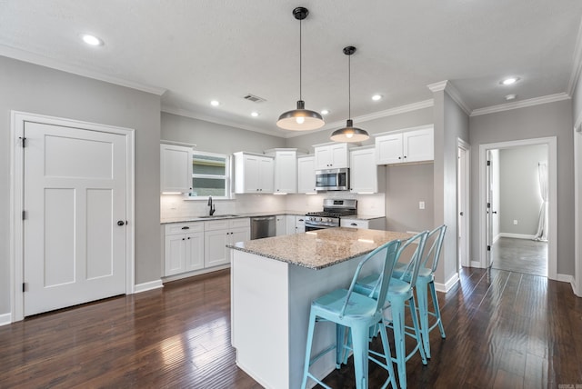 kitchen with visible vents, appliances with stainless steel finishes, dark wood-type flooring, white cabinets, and a sink