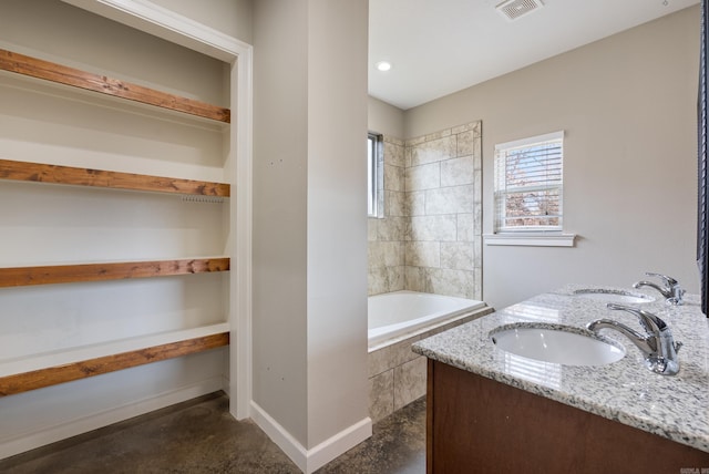 bathroom featuring double vanity, a sink, visible vents, and baseboards