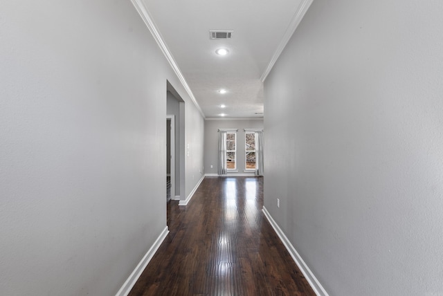 hallway featuring baseboards, visible vents, ornamental molding, wood finished floors, and recessed lighting