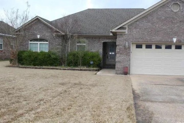 single story home featuring a garage, brick siding, and driveway