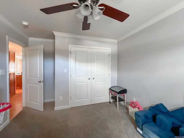 sitting room with ceiling fan, baseboards, carpet floors, and ornamental molding