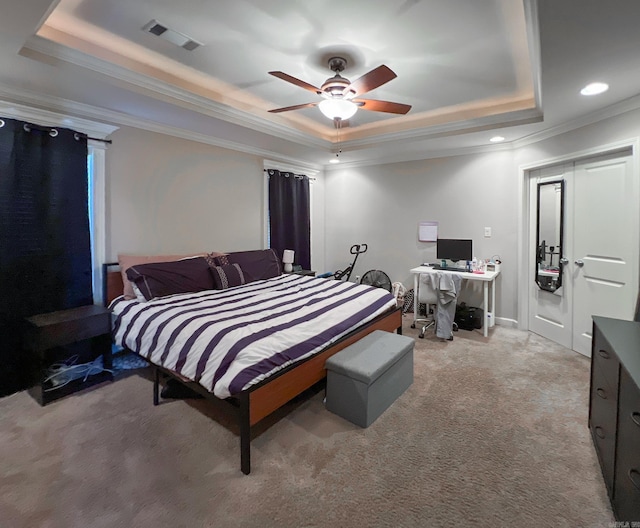 bedroom with visible vents, crown molding, ceiling fan, light colored carpet, and a raised ceiling