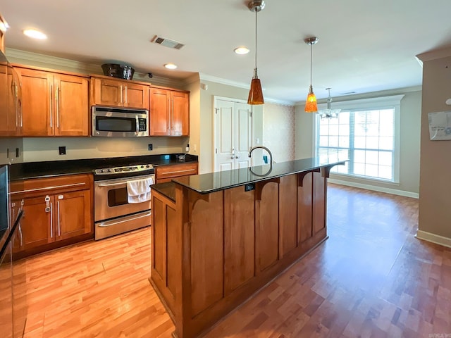 kitchen with dark countertops, visible vents, brown cabinets, and stainless steel appliances