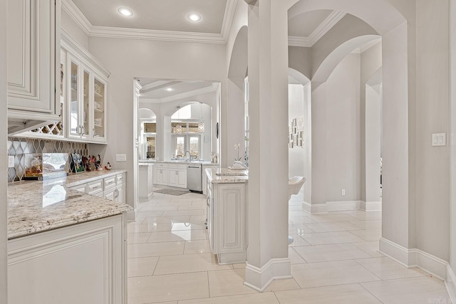 interior space with light tile patterned floors, recessed lighting, a sink, baseboards, and crown molding