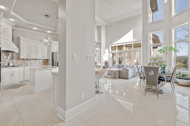 kitchen with a high ceiling, a chandelier, and backsplash