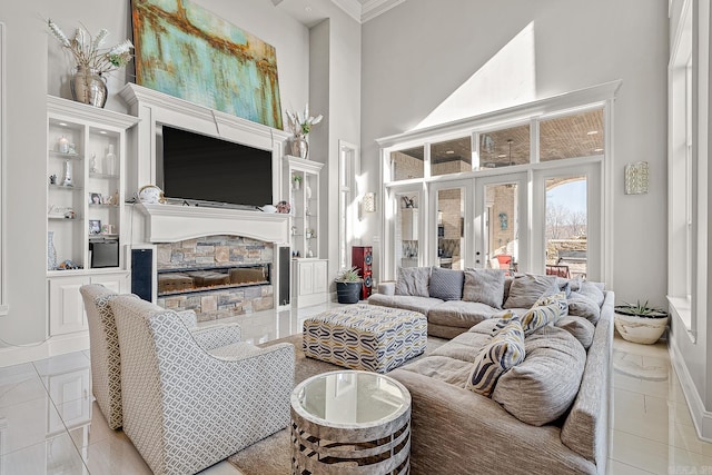 living area with a towering ceiling, tile patterned flooring, french doors, built in shelves, and a fireplace