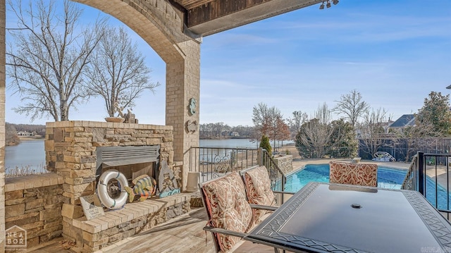 view of patio / terrace with an outdoor stone fireplace and a water view