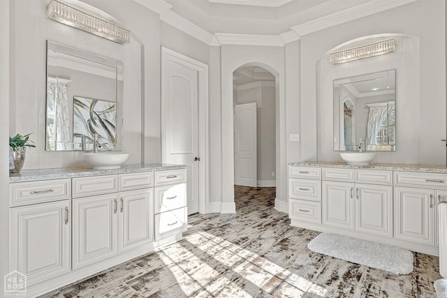 full bath with crown molding, two vanities, and a sink