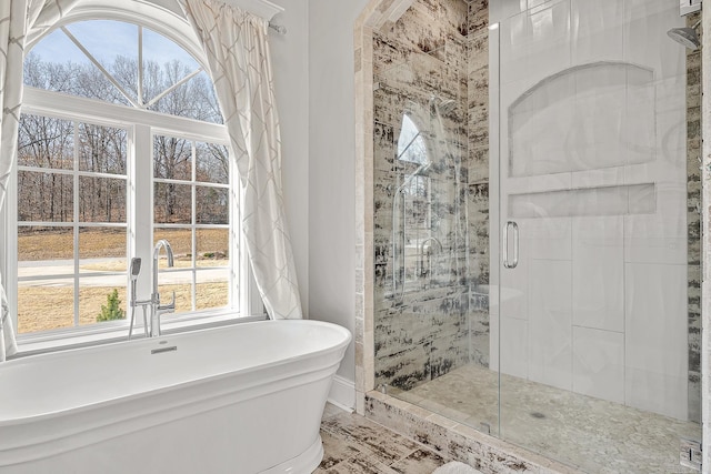 bathroom with a freestanding tub and a shower stall