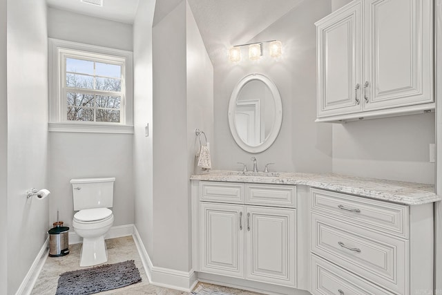 bathroom with visible vents, vanity, toilet, and baseboards