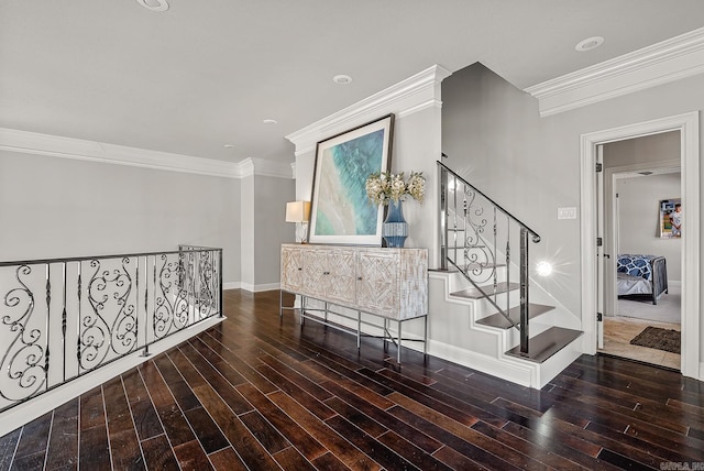 hallway with stairs, baseboards, wood finished floors, and crown molding