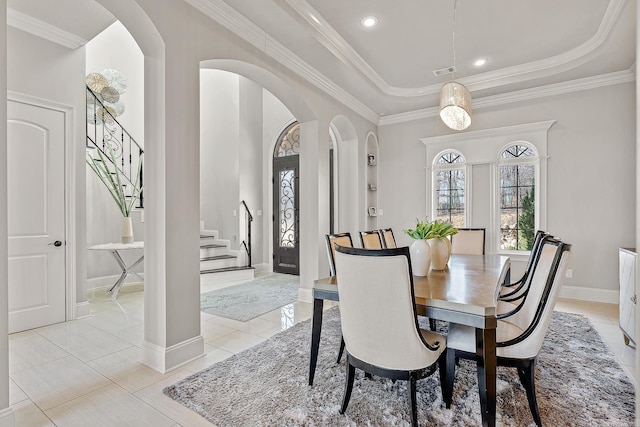 dining area with visible vents, stairs, arched walkways, and a tray ceiling