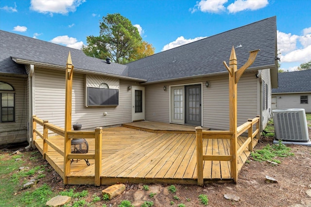 rear view of property featuring roof with shingles, cooling unit, and a wooden deck