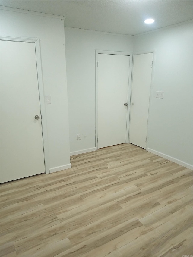 unfurnished room with recessed lighting, light wood-style flooring, and baseboards