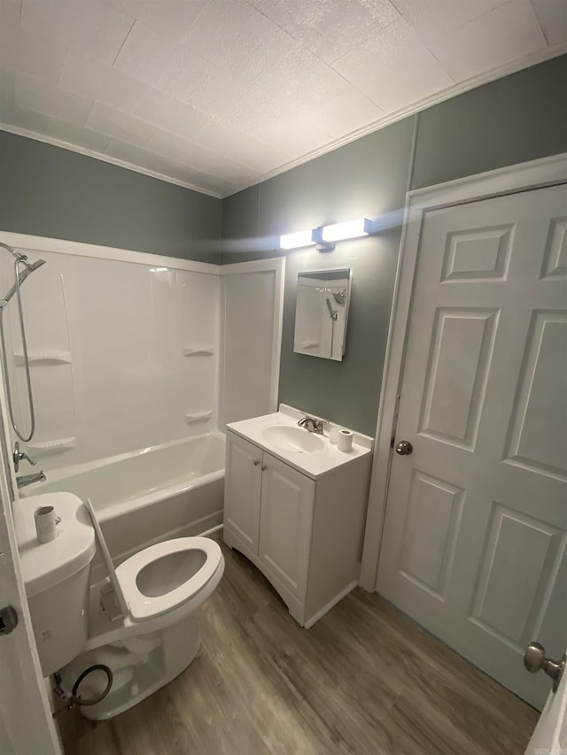 bathroom featuring toilet, shower / bath combination, wood finished floors, and vanity