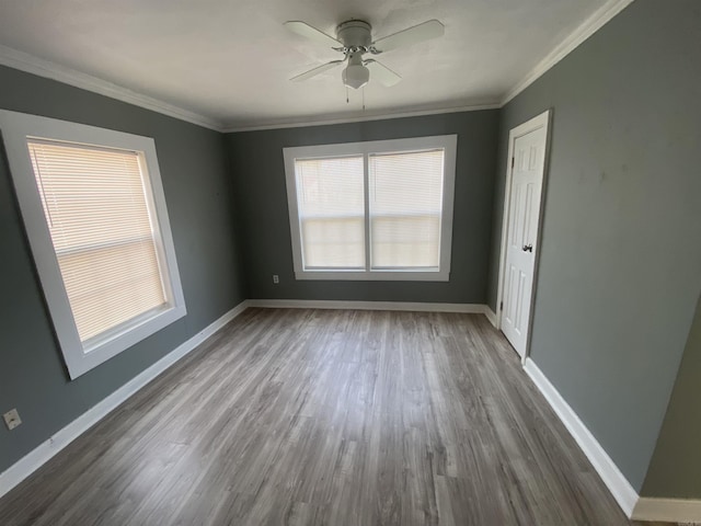 empty room featuring ornamental molding, dark wood-style flooring, and baseboards