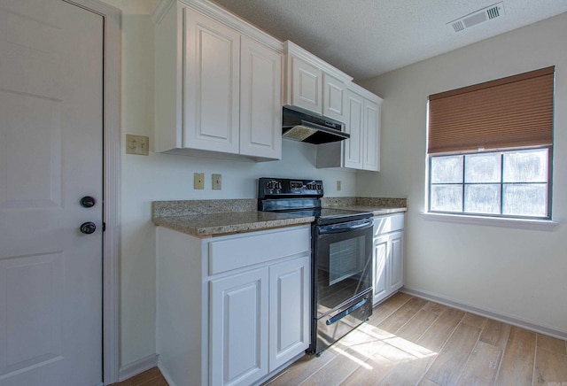 kitchen featuring black electric range, visible vents, white cabinetry, light wood-type flooring, and under cabinet range hood