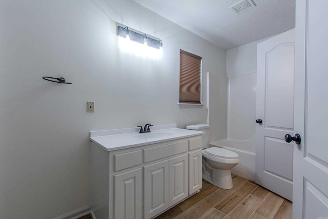 bathroom with visible vents, toilet, wood finished floors, a textured ceiling, and vanity