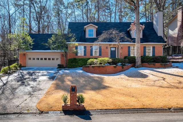 cape cod home featuring brick siding and driveway