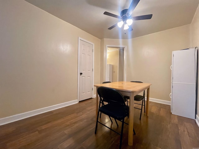 dining room featuring a ceiling fan, baseboards, and dark wood-style flooring