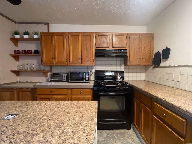 kitchen with light countertops, stainless steel microwave, backsplash, gas stove, and under cabinet range hood