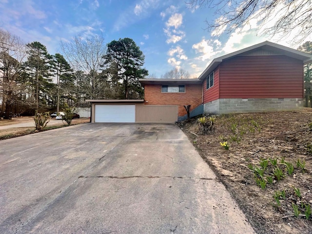 view of property exterior featuring driveway, crawl space, and a garage