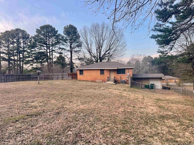 rear view of property with brick siding, a lawn, and a fenced backyard