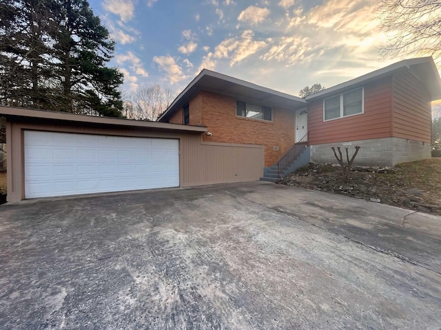 view of home's exterior with brick siding, driveway, and an attached garage