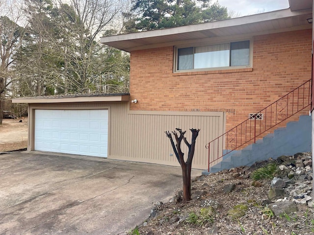 view of property exterior featuring a garage, brick siding, and stairs