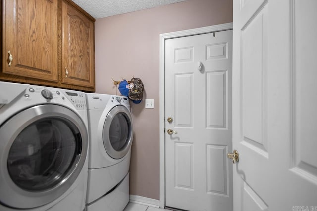 laundry area featuring washer and dryer, cabinet space, and a textured ceiling