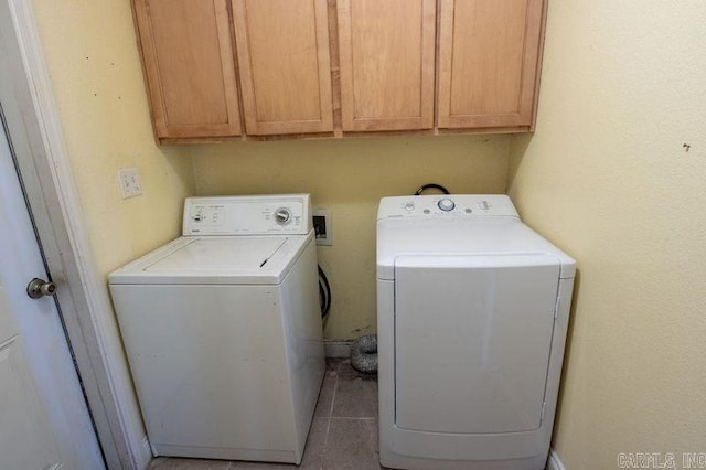 washroom featuring cabinet space, washer and dryer, and tile patterned floors