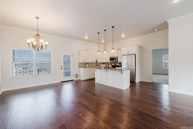 kitchen with tasteful backsplash, dark wood-style floors, appliances with stainless steel finishes, a kitchen island with sink, and white cabinetry