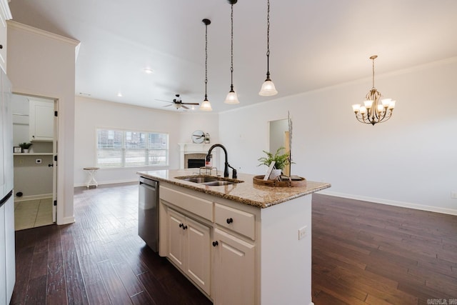 kitchen featuring light stone counters, dark wood finished floors, a fireplace, a sink, and dishwasher