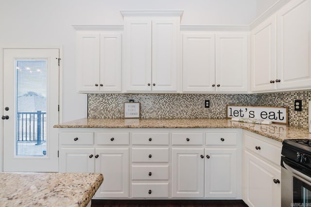 kitchen with tasteful backsplash and white cabinetry