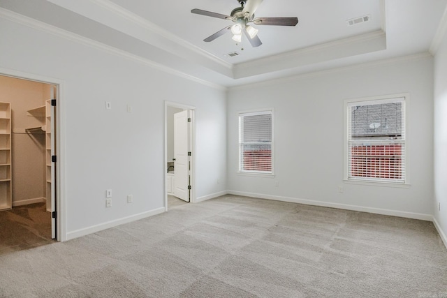 spare room with a wealth of natural light, a tray ceiling, and visible vents