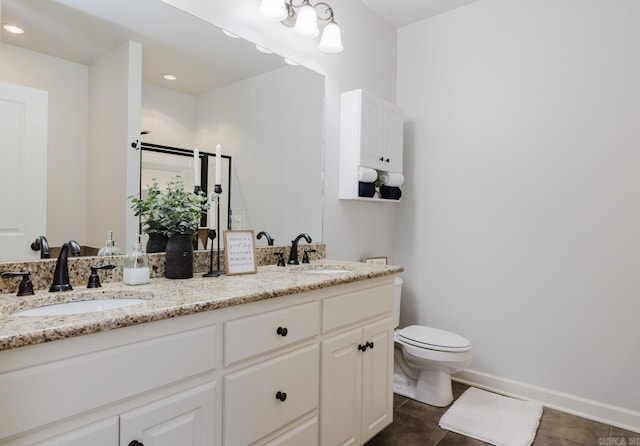 full bathroom featuring double vanity, a sink, toilet, and tile patterned floors