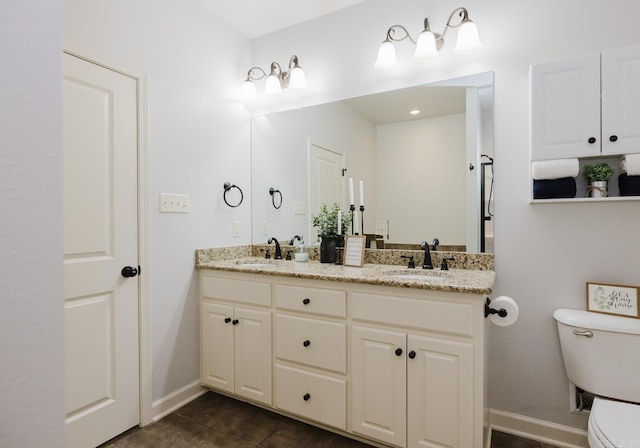 bathroom featuring tile patterned floors, a sink, toilet, and double vanity