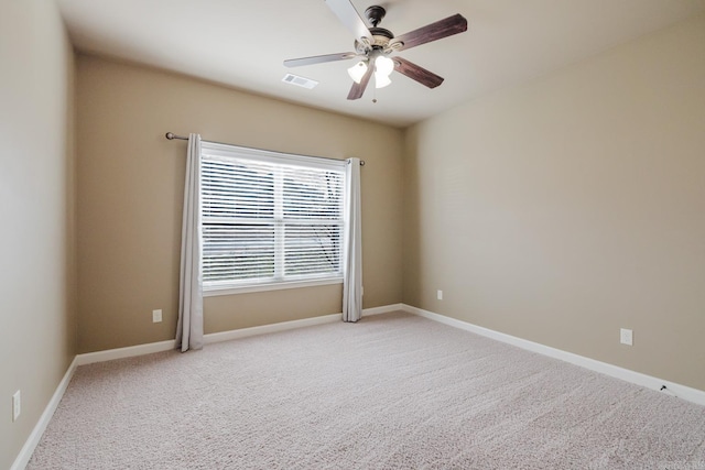 empty room featuring light carpet, baseboards, visible vents, and a ceiling fan