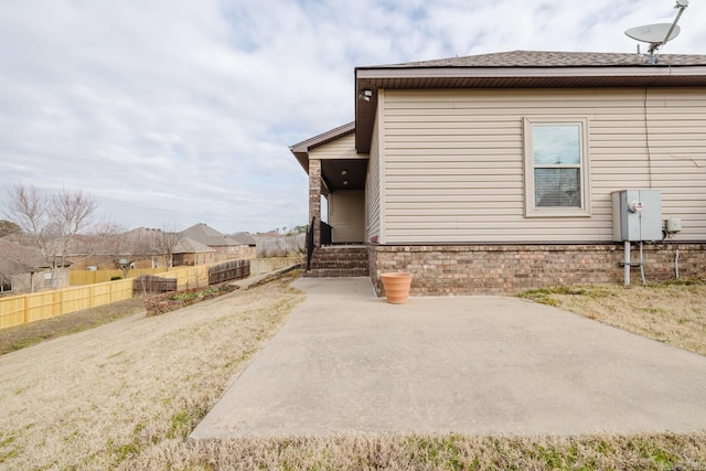 view of side of home with a patio area and fence