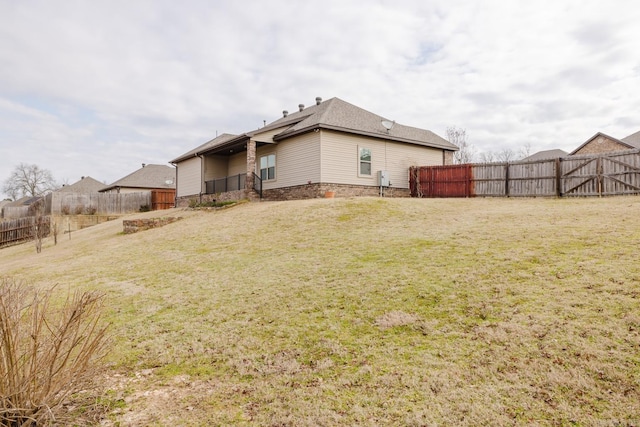 rear view of property with a yard and fence