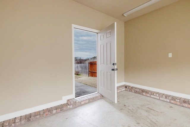 view of exterior entry featuring a patio area and fence