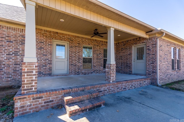 property entrance with ceiling fan, brick siding, and a porch