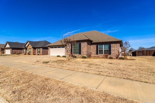 ranch-style home featuring a garage, brick siding, a shingled roof, fence, and driveway